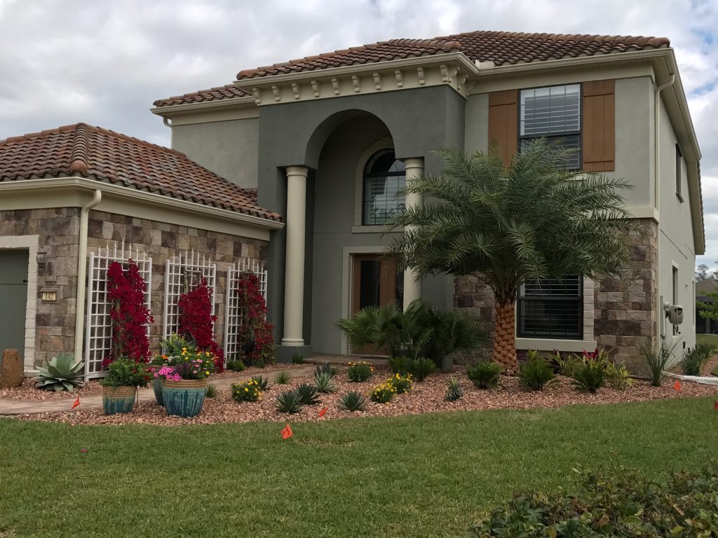 House with clean flower garden and palm tree