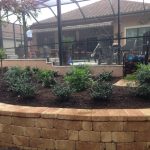 Small garden with a stone retaining wall by the deck.